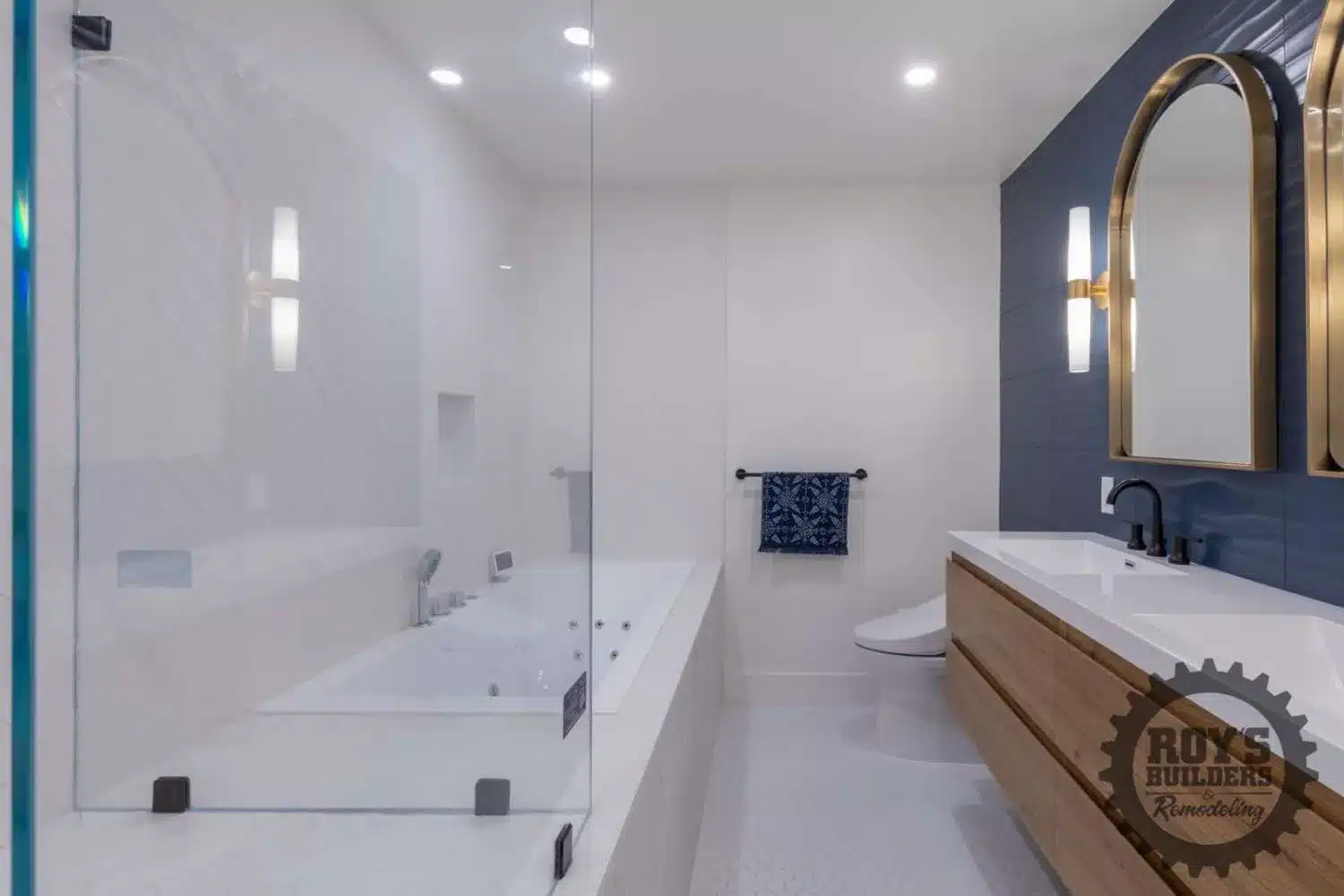 Glass shower door and a large white tub in a modern bathroom with white walls