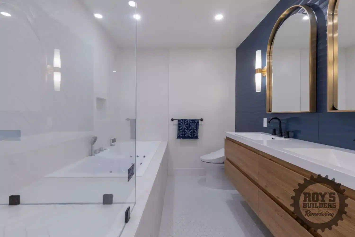 Double vanity with a wood cabinet, white countertop, two gold arch mirrors