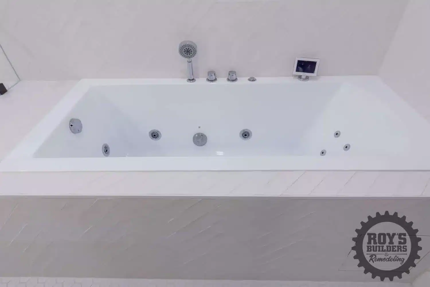 Glass shower door and a large white tub in a modern bathroom with white walls