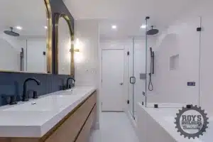 Double vanity with a wood cabinet, white countertop, two gold arch mirrors