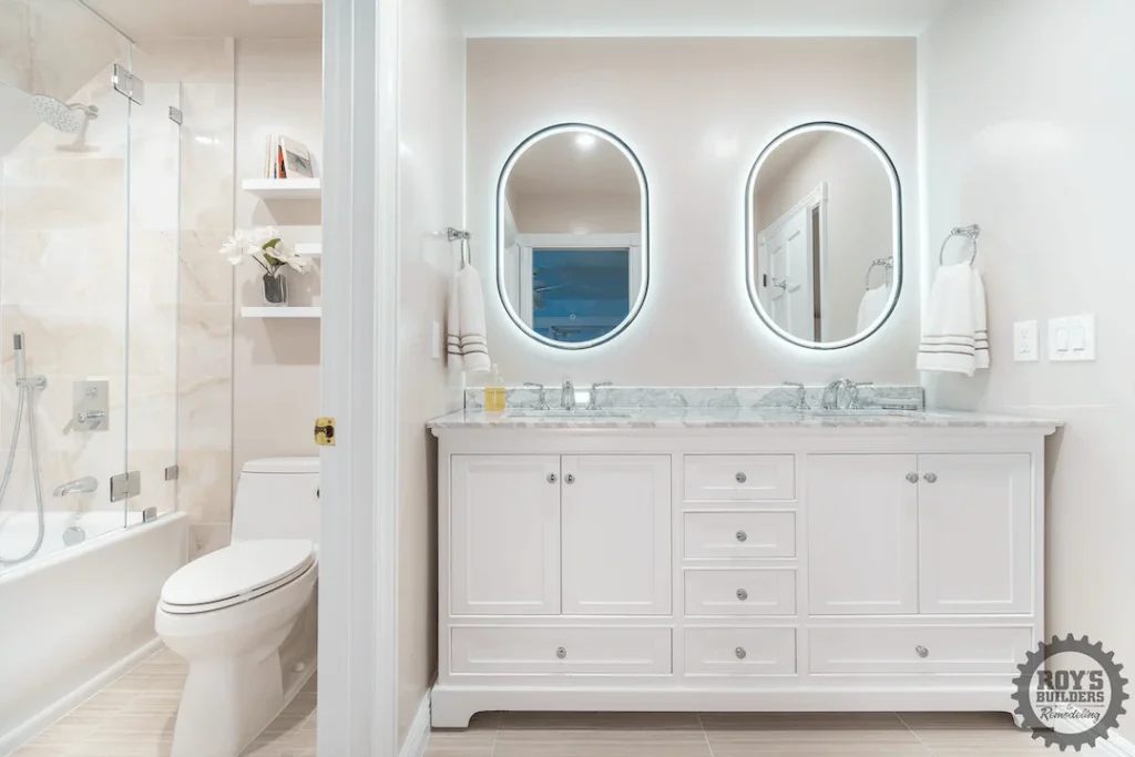 White double vanity with backlit oval mirrors
