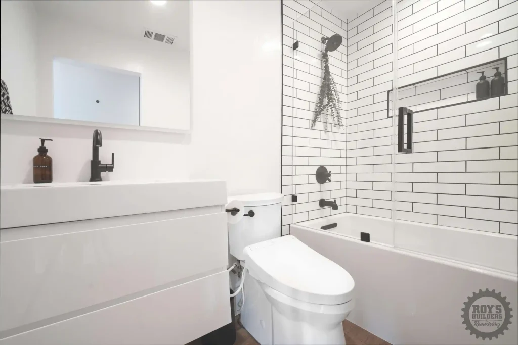 White tiled bathroom with shower and elegant fixtures