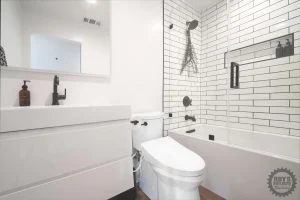 White tiled bathroom with shower and elegant fixtures