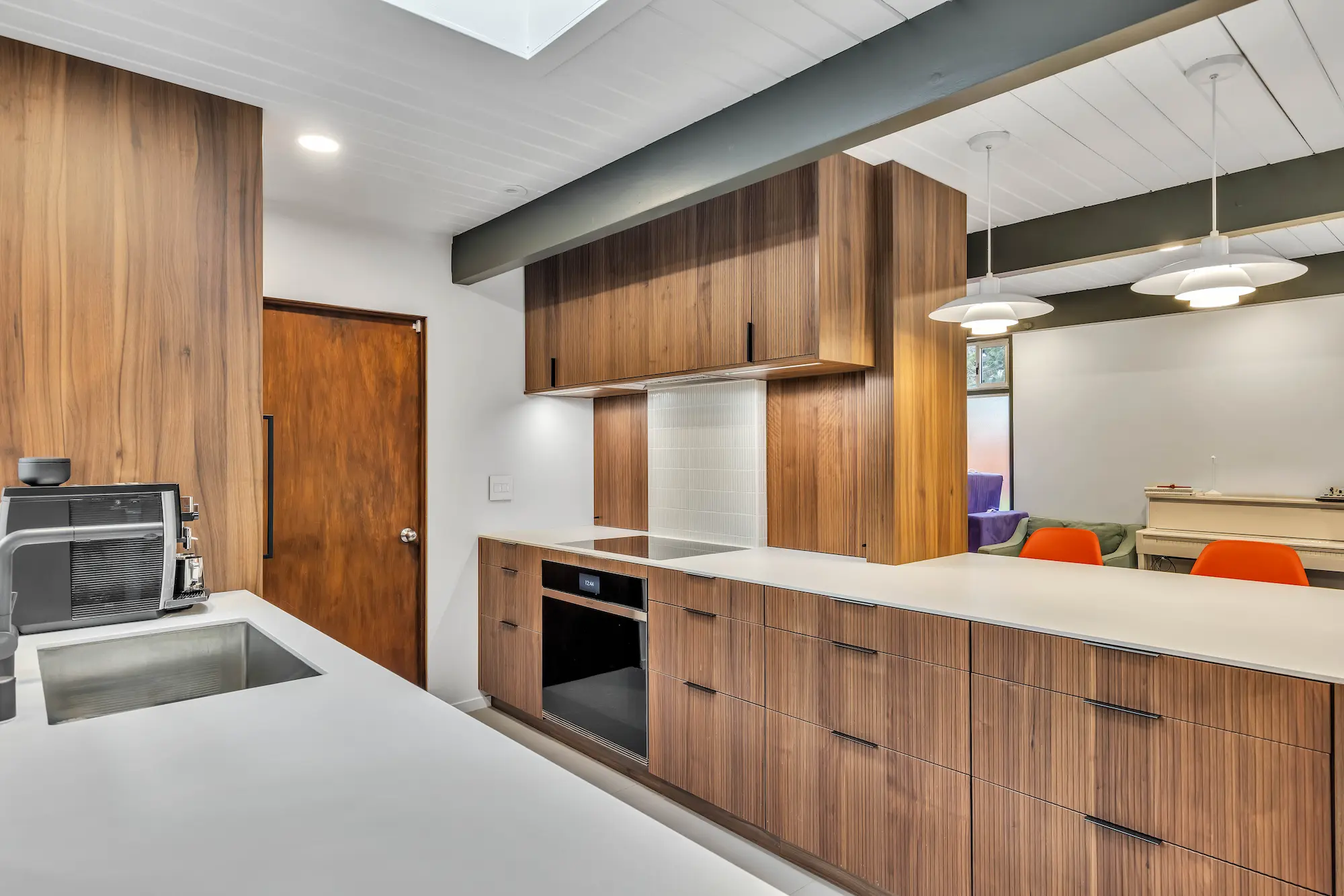 A close-up of a long wooden counter with an integrated black oven and white countertop.