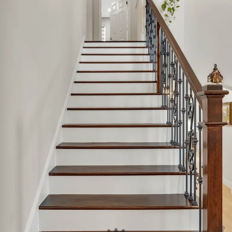 Close-up of staircase with wooden steps and iron balusters
