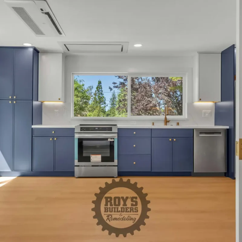 Bright open kitchen layout with a view of the blue cabinets and sliding glass patio door.