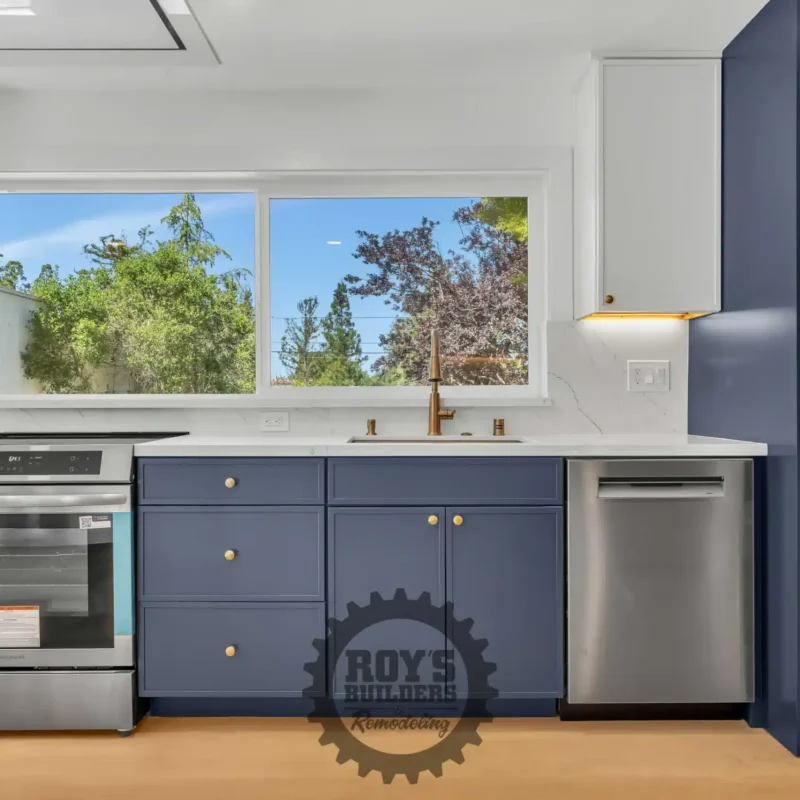 Close-up of the kitchen workspace showcasing the stove, blue cabinets, and a white refrigerator.