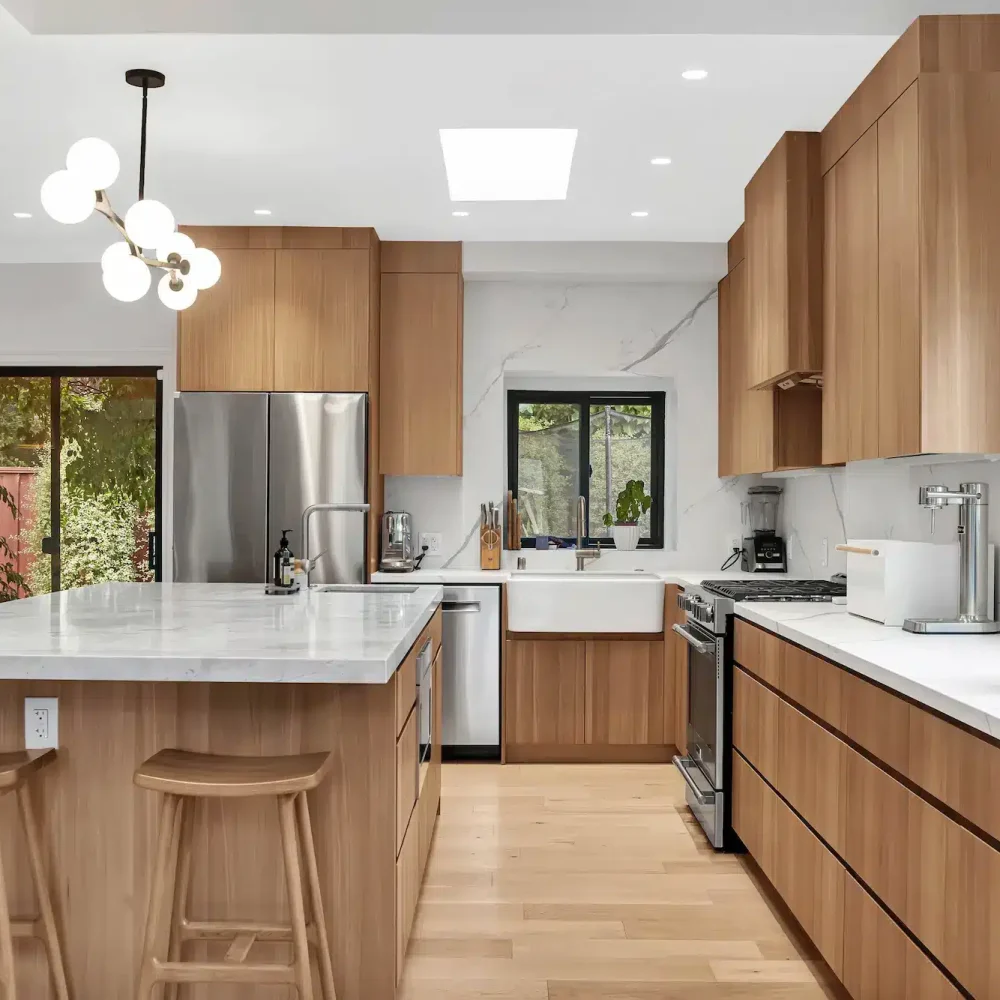 A kitchen featuring light-colored wood cabinets, a white island, and a modern branching light fixture.