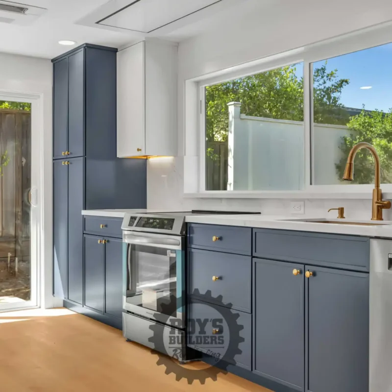 Corner kitchen view showing the sink under a bright window and a dishwasher.