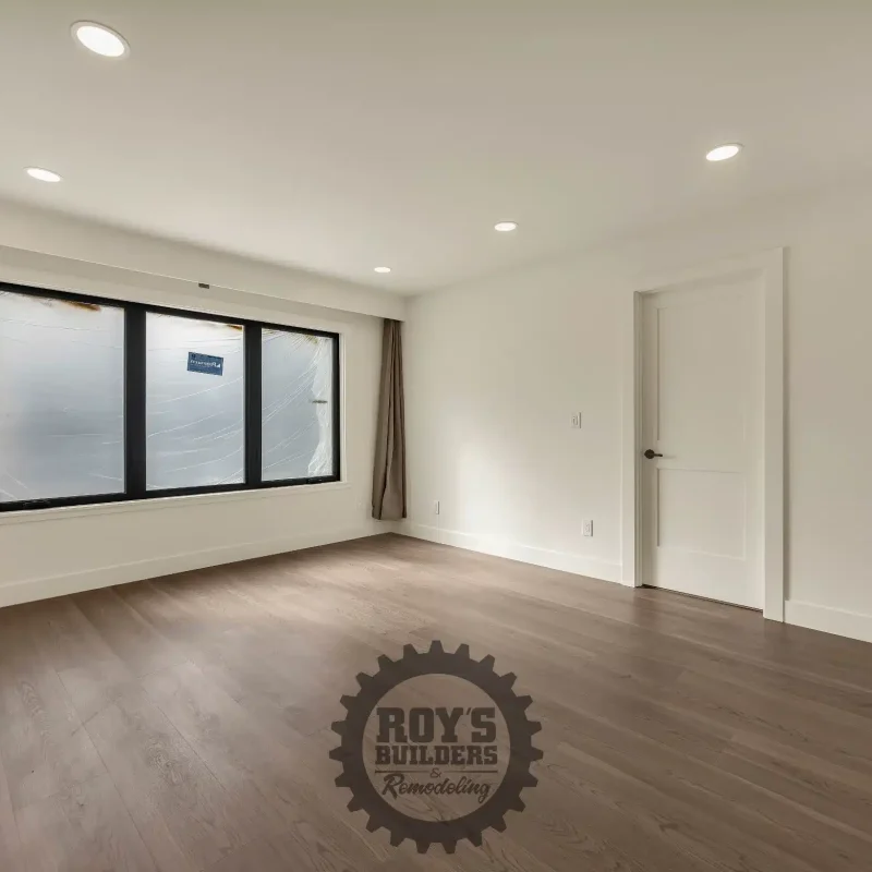 Bright, empty bedroom showcasing large windows and a neutral design.