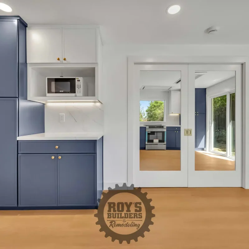 Full view of a blue kitchen storage unit and a white entryway door with glass panes.