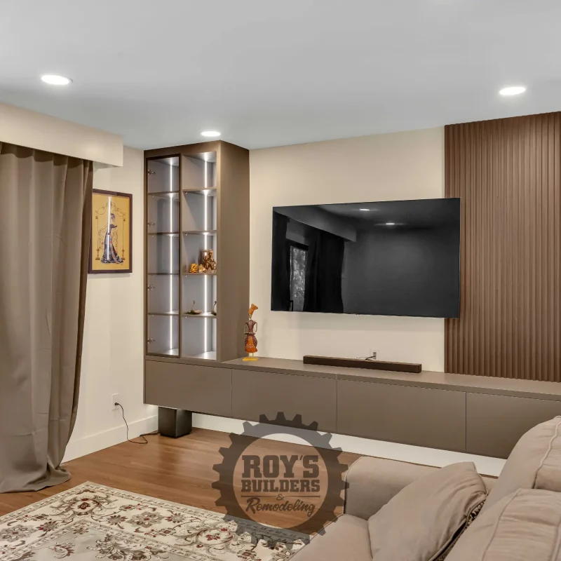 Open-concept living room featuring light wood cabinetry and a flat-screen TV.