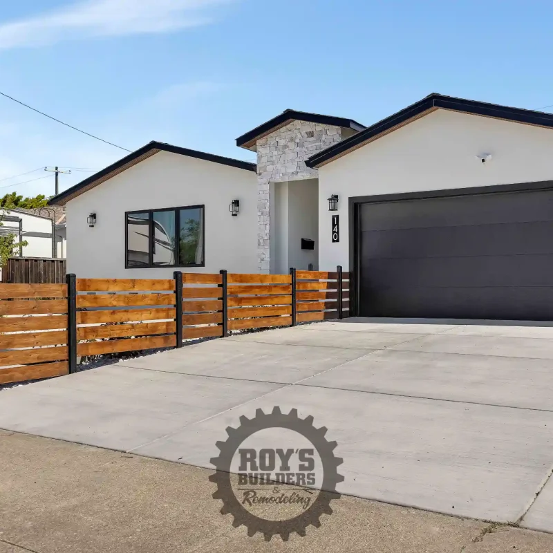 Paved front yard courtyard leading to a modern home entrance.