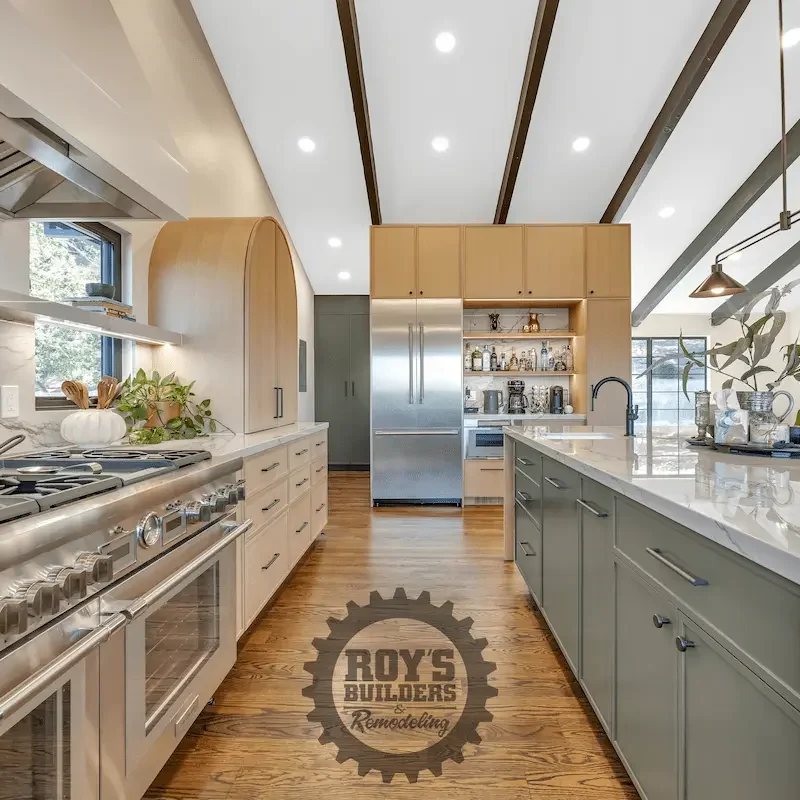 Kitchen with green cabinetry and modern appliances.