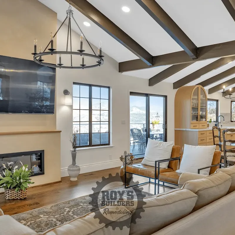 Living room with vaulted wooden ceiling and large windows.