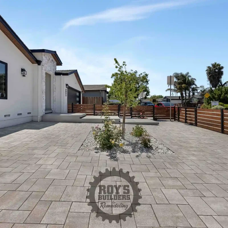 Side view of a modern stucco home with a gravel and paved pathway.