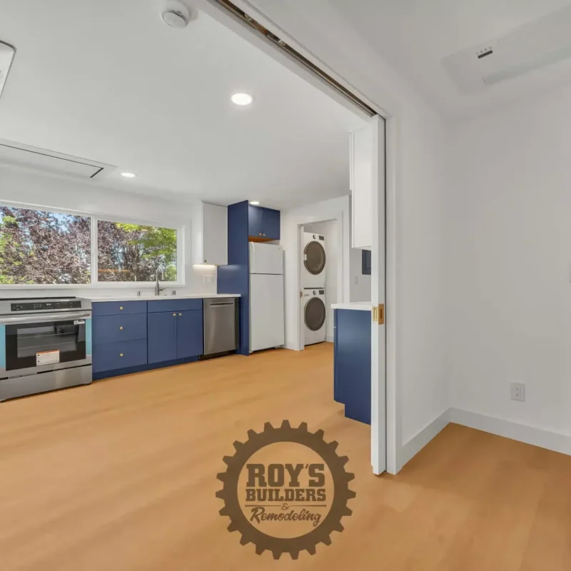 Wide-angle view of the blue and white kitchen looking toward an entry door.