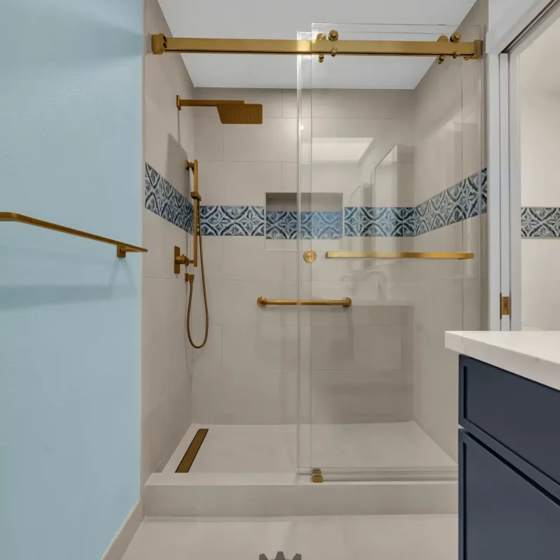 Alternate angle of the glass shower enclosure showing the light blue painted accent wall.